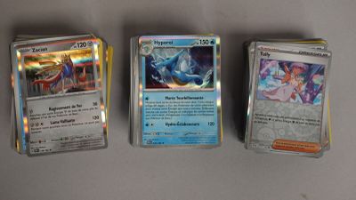 Quatre types différents de cartes Pokémon sont alignées sur une table