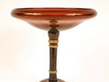 un bol en verre reposant sur un socle en bois, posé sur une surface blanche