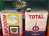 plusieurs bidons de différents types d'essence sont posés sur une surface rouge