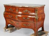 a wooden chest of drawers with marble top on casteors