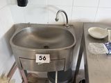 a sink in the corner of a kitchen with a lot of clutter on the counter