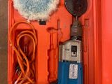 une boîte orange avec une perceuse bleue et rouge et un pinceau bleu et blanc