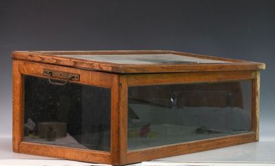 une petite boîte en bois avec un couvercle en verre, posée sur une table