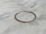 a close up of a silver bracelet on a marble surface