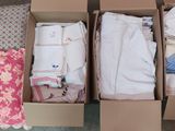 deux cartons de vêtements et un oreiller par terre