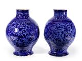 deux vases bleus posés l'un à côté de l'autre sur une surface blanche