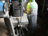 a small air compressor sitting on a cart in a garage