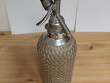 a metal bottle with a metal handle on a wooden table