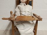 a doll that is sitting in a chair on the floor