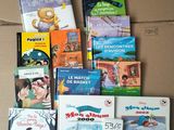 de nombreux livres pour enfants dans une boîte en carton posée par terre