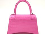 pink crocodile skin handbag on a white background