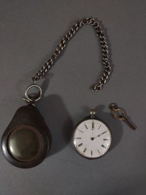 a pocket watch and a keychain on a table