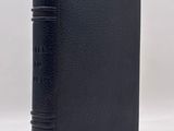 un livre noir à la couverture noire posé sur une surface blanche