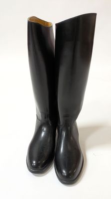 a pair of black boots sitting on top of a white surface