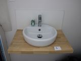 a white sink sitting on a wooden counter in a bathroom