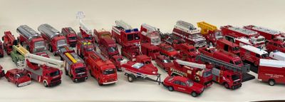 beaucoup de camions de pompiers miniatures posés sur la table