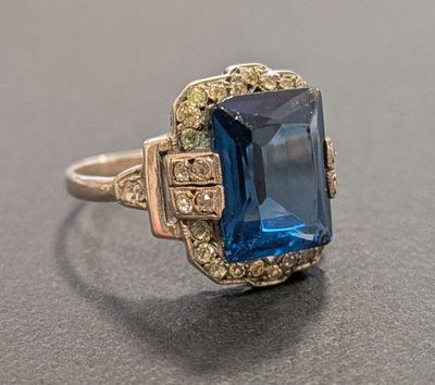 a close up of a ring with a blue stone in it