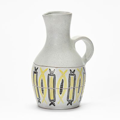 a white vase with yellow and black designs on it