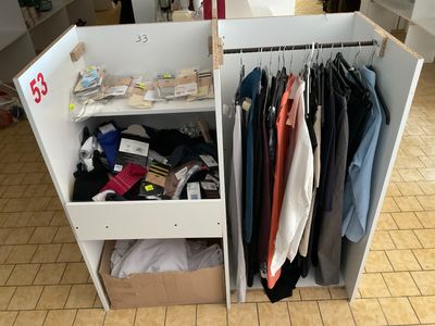 une armoire blanche sur laquelle sont posés des vêtements, dans une pièce