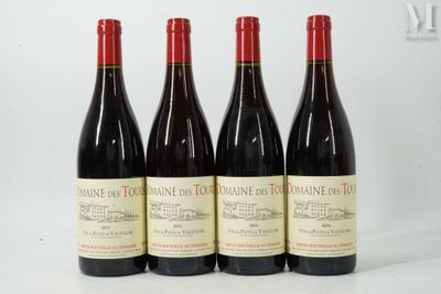 quatre bouteilles de vin sont alignées sur une surface blanche
