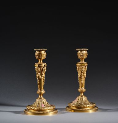 pair of antique brass candlesticks on a grey background