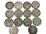 a close up of a bunch of silver coins on a white surface