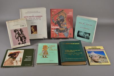 Plusieurs livres sont posés sur une table devant un fond gris.