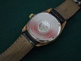 a close up of a wrist watch on a green surface