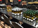 de nombreuses bouteilles de vin posées sur une table dans une pièce