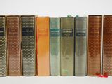 plusieurs vieux livres sont alignés sur une surface blanche