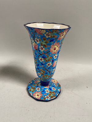 une image représentant un vase bleu posé sur une table blanche