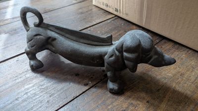 une petite statuette représentant un teckel posée sur un parquet