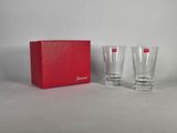deux verres dans une boîte rouge et une boîte rouge posée sur une surface blanche