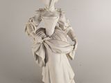 statue d'une femme tenant un panier de fleurs dans ses mains