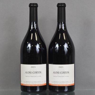 two bottles of wine sitting on top of a table next to each other