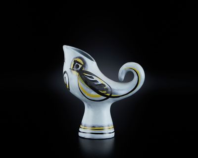 un vase blanc orné d'un oiseau jaune et noir