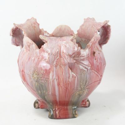 a pink vase sitting on a white surface with a white background
