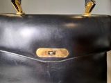 a black purse with a gold handle on a table