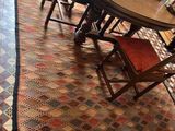 une table et des chaises dans une pièce avec un tapis au sol