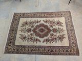 rug on the floor with a chair and a table in the background