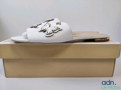 mules en cuir blanc ornées d'un motif floral sur la pointe et au talon