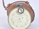 a small clock with a leather case on it