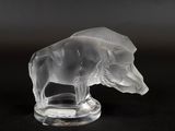 figurine en verre transparent représentant un ours, posée sur un socle transparent