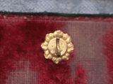 a close up of a gold button on a piece of cloth