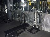 une salle de sport équipée d'un banc, d'haltères et d'autres appareils