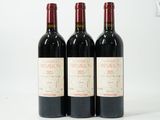 trois bouteilles de vin rouge posées sur une table blanche