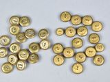 some gold buttons are sitting on a white surface