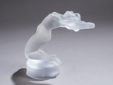 une sculpture en verre représentant une femme sur un fond blanc