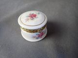 a small white box with flowers on it sitting on a table