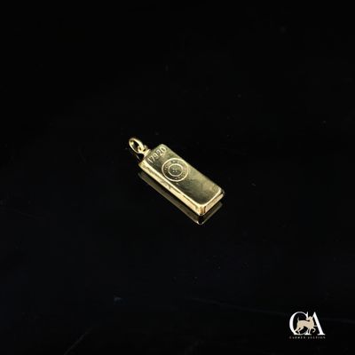 un pendentif plaqué or représentant un appareil photo sur fond noir